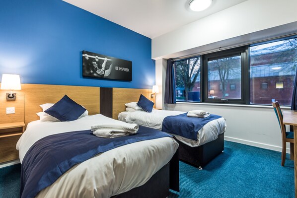 A hotel room with two beds, a large window, and a motivational poster on the wall. - Lilleshall National Sports Centre (Newport)