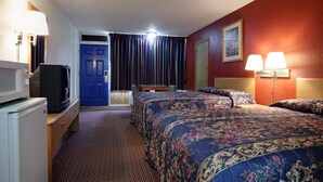 A hotel room with a bed, two bedside lamps, a desk with a television, and a microwave.
