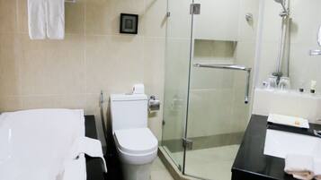 Un baño moderno con ducha acristalada, inodoro y lavabo con encimera negra.