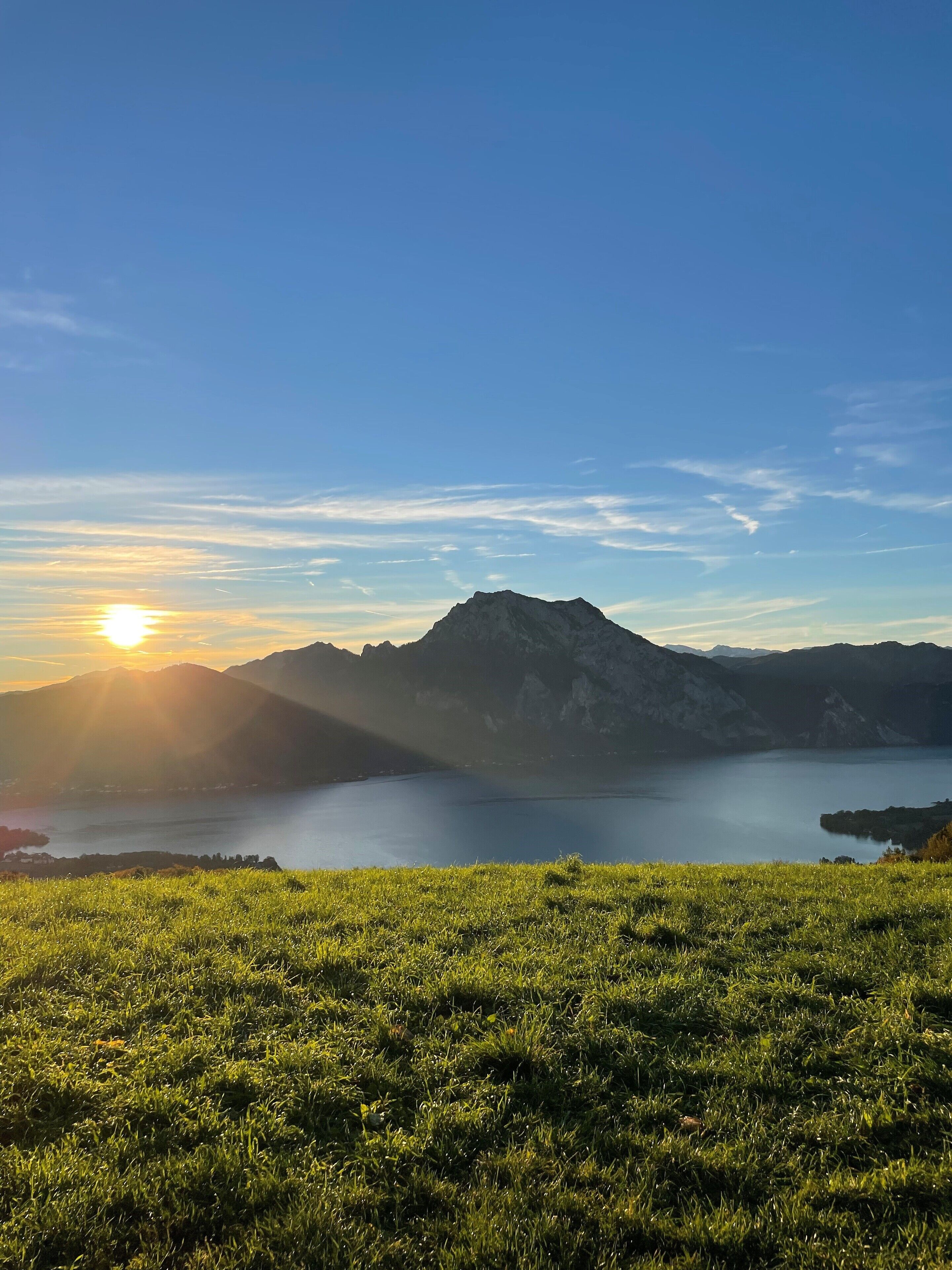 Eine Berglandschaft mit einem See und einem grasbewachsen Vordergrund.