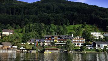 Une propriété située au bord d’un lac, comprenant plusieurs bâtiments, notamment un hôtel doté de balcons et un restaurant.