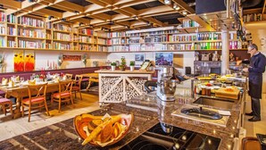 A restaurant with a library, a dining area, and a kitchen. - Landhotel Gasthof Grunberg (Gmunden)