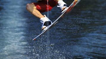 Eine Person treibt auf dem Wasser Wakeboard.
