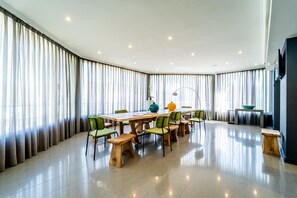 A modern dining area with a long table, green chairs, and a wooden bench. - Jardines La Tejera (Olula Del Rio)