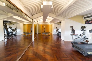Una palestra con attrezzature per esercizi, pavimenti in legno e un grande specchio.