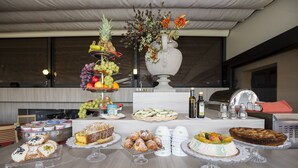 A buffet table with various desserts and a fruit display. - Hotel Giardino Inglese (Palermo)