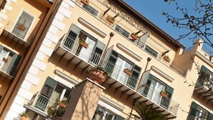 A hotel facade with balconies, potted plants, and a sign indicating it is a hotel. - Hotel Giardino Inglese (Palermo)