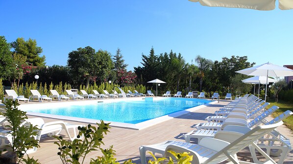 Outdoor pool, a waterfall pool, pool umbrellas, pool loungers