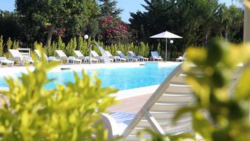 Area piscina con lettini e elemento d'acqua.