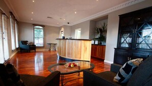 A spacious living room with a glass coffee table, a sofa, and a dining area with a wooden cabinet.