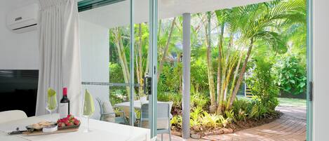 A modern room with a glass door leading to a garden.