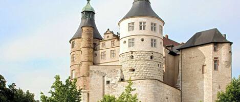 Un castillo histórico con múltiples torres y un muro fortificado.