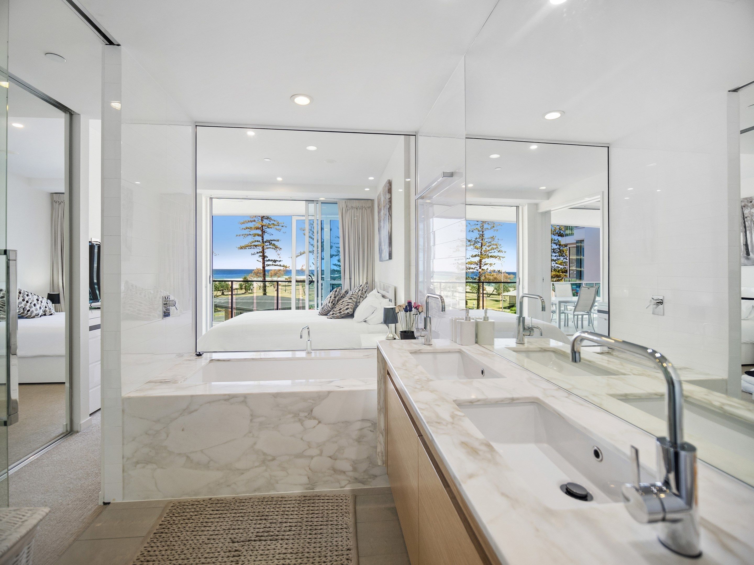 Un baño moderno con un espejo grande, una bañera y zona de ducha.