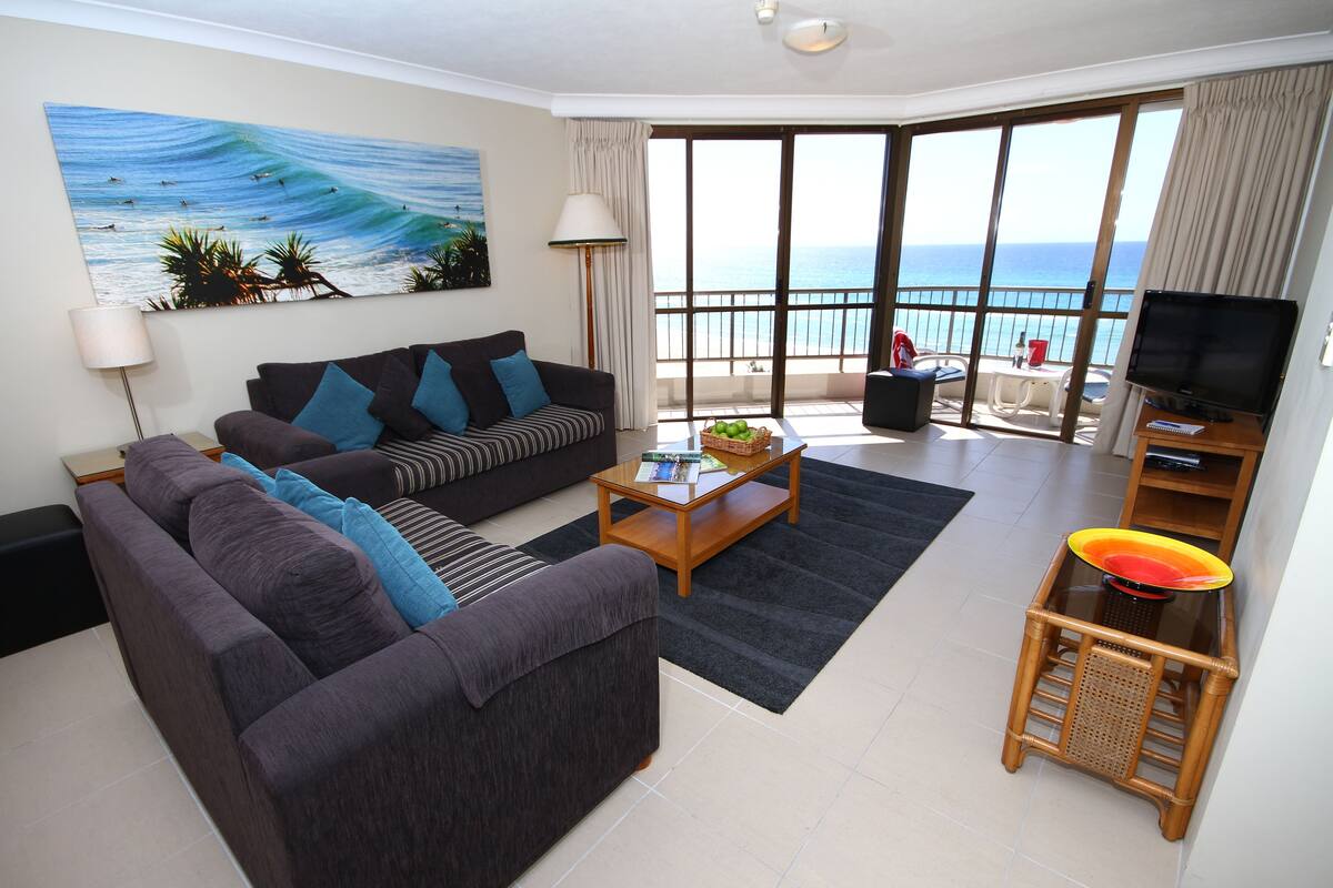 A living room with a sofa, a coffee table, and a television.