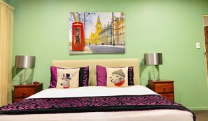 A bed with a white headboard, two bedside tables with lamps, and a painting of a red telephone booth and a clock tower on the wall. - Aussie Rest Motel (Cessnock)
