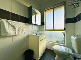 Un baño pequeño con inodoro, lavamanos y espejo.