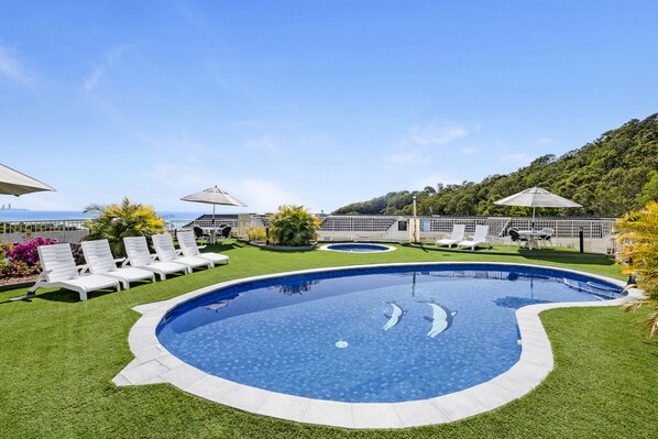 Outdoor pool, a heated pool, pool umbrellas, pool loungers
