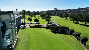 Un campo de golf con un edificio moderno a su lado.