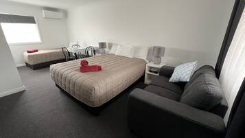 Ett hotellrum med en stor säng, en soffa, ett skrivbord och en stol.