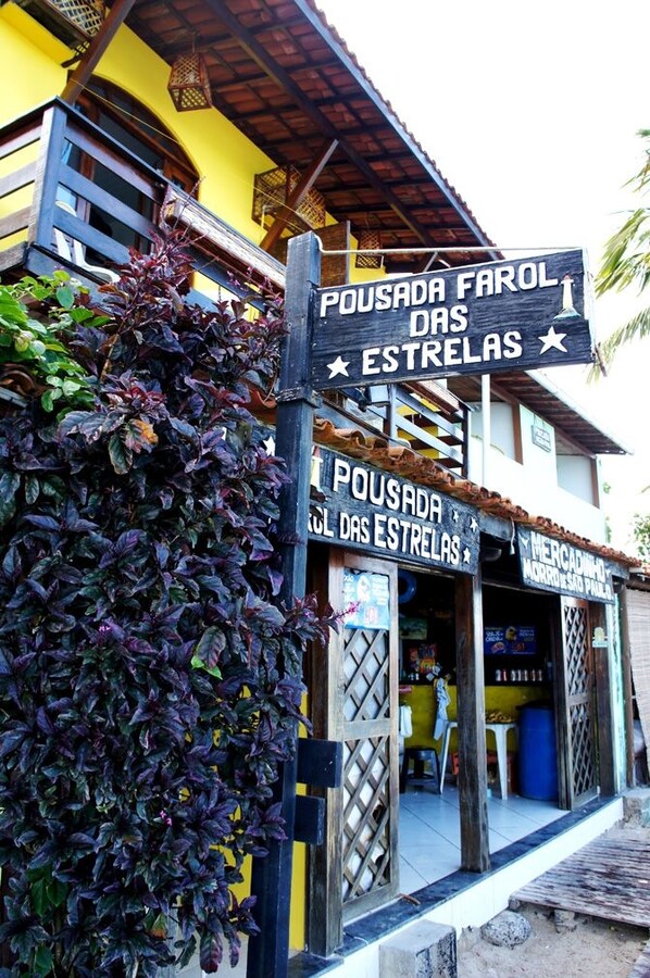 A building with a sign that reads 'POUSADA FAROL DAS ESTRELAS' and a visible entrance. - Pousada Grauçá (Morro de Sao Paulo)
