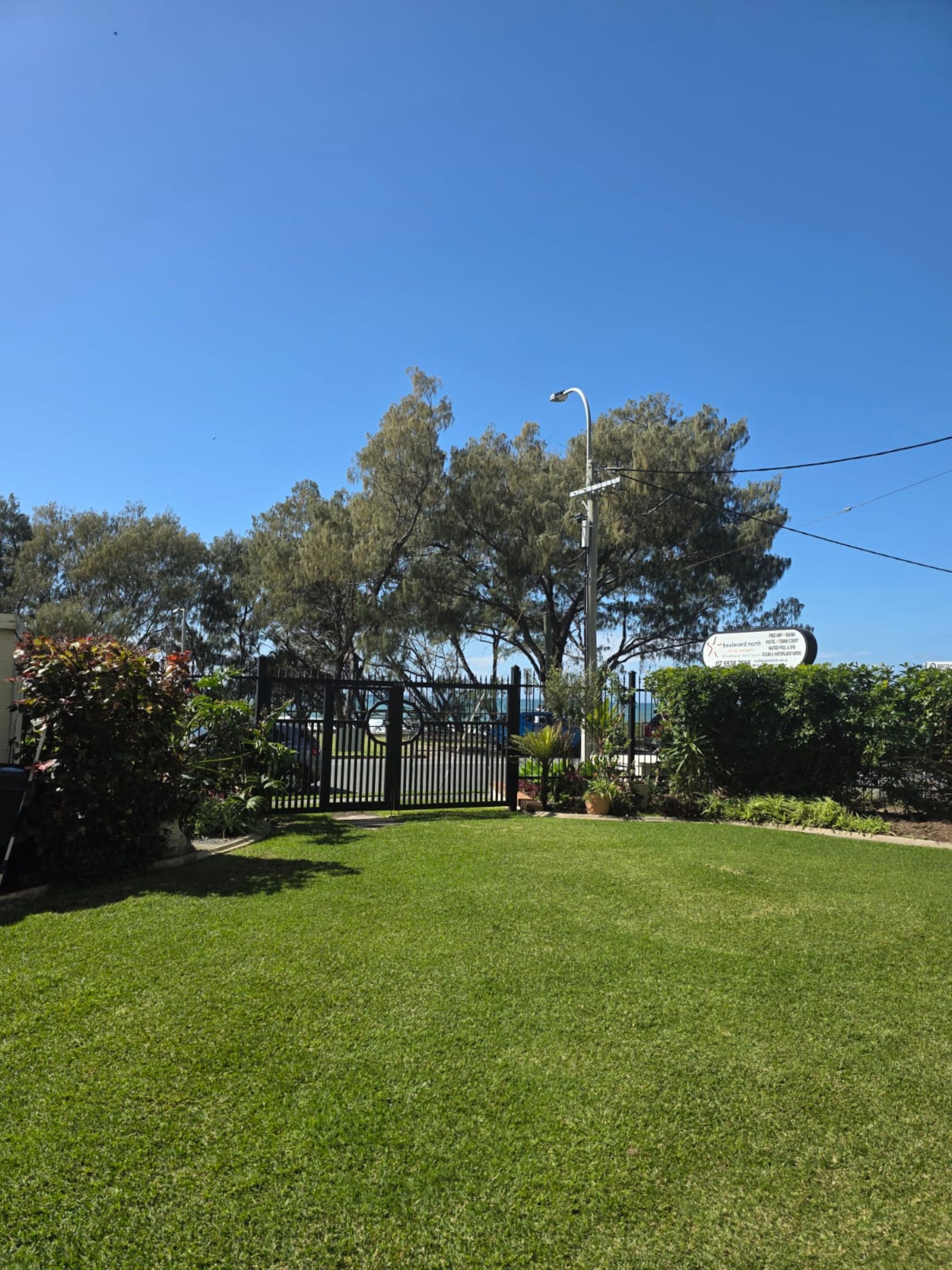 A well-maintained lawn with a street lamp and a sign indicating 'Boulevard North'.