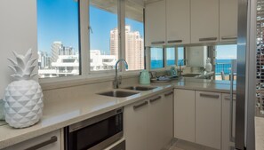 Una cocina moderna con vista al océano y edificios altos.