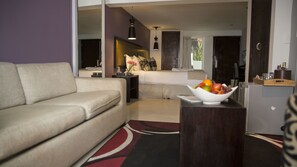 Habitación triple Deluxe | Área de sala de estar | Televisión de 32 pulgadas con canales vía satélite