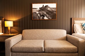 A room with a sofa, a framed picture of horses, a lamp, and a bed with pillows. - Nightcap at Archer Hotel (Nowra)