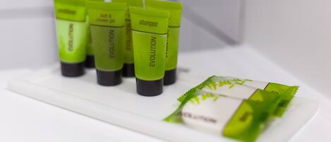 A set of green tubes labeled 'EVOLUTION' on a white surface, likely in a bathroom setting.