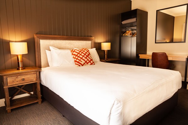 A neatly made bed with white linens and a single decorative pillow, flanked by two bedside tables with lamps. - Nightcap at Archer Hotel (Nowra)