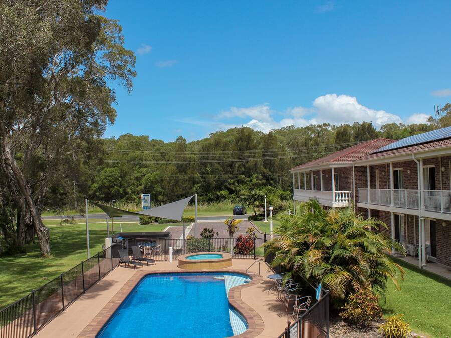 Una piscina al aire libre, sillones reclinables de piscina