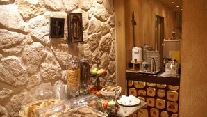 Un bufé de desayuno con diversas opciones de comida y un fondo de pared de piedra.