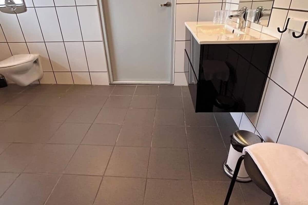 A modern bathroom with a toilet, sink, and mirror.