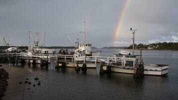 A dock with boats and a rainbow in the background.