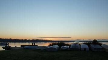 A lakeside view with several tents and a dock.