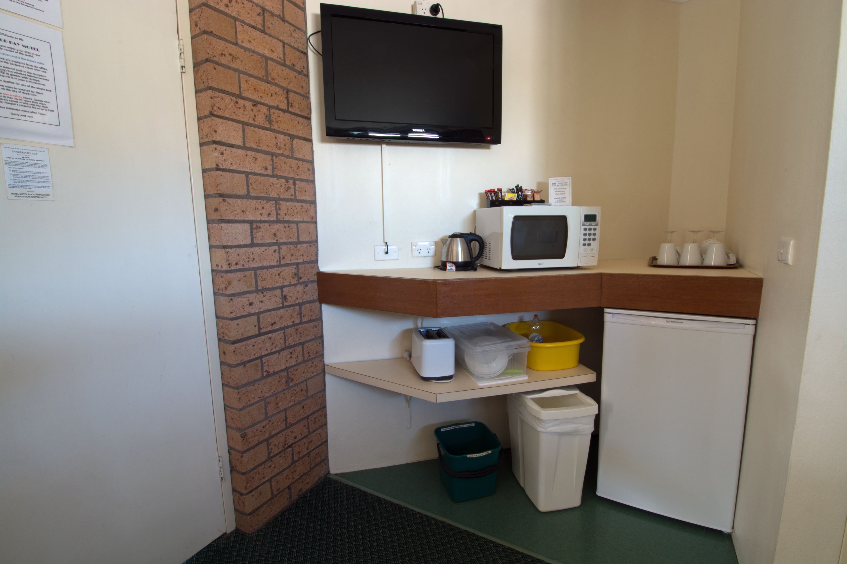 A compact kitchenette with a microwave, kettle, and small refrigerator.