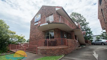 Un motel de ladrillo con un balcón y un letrero que indica las habitaciones del 7 al 12.
