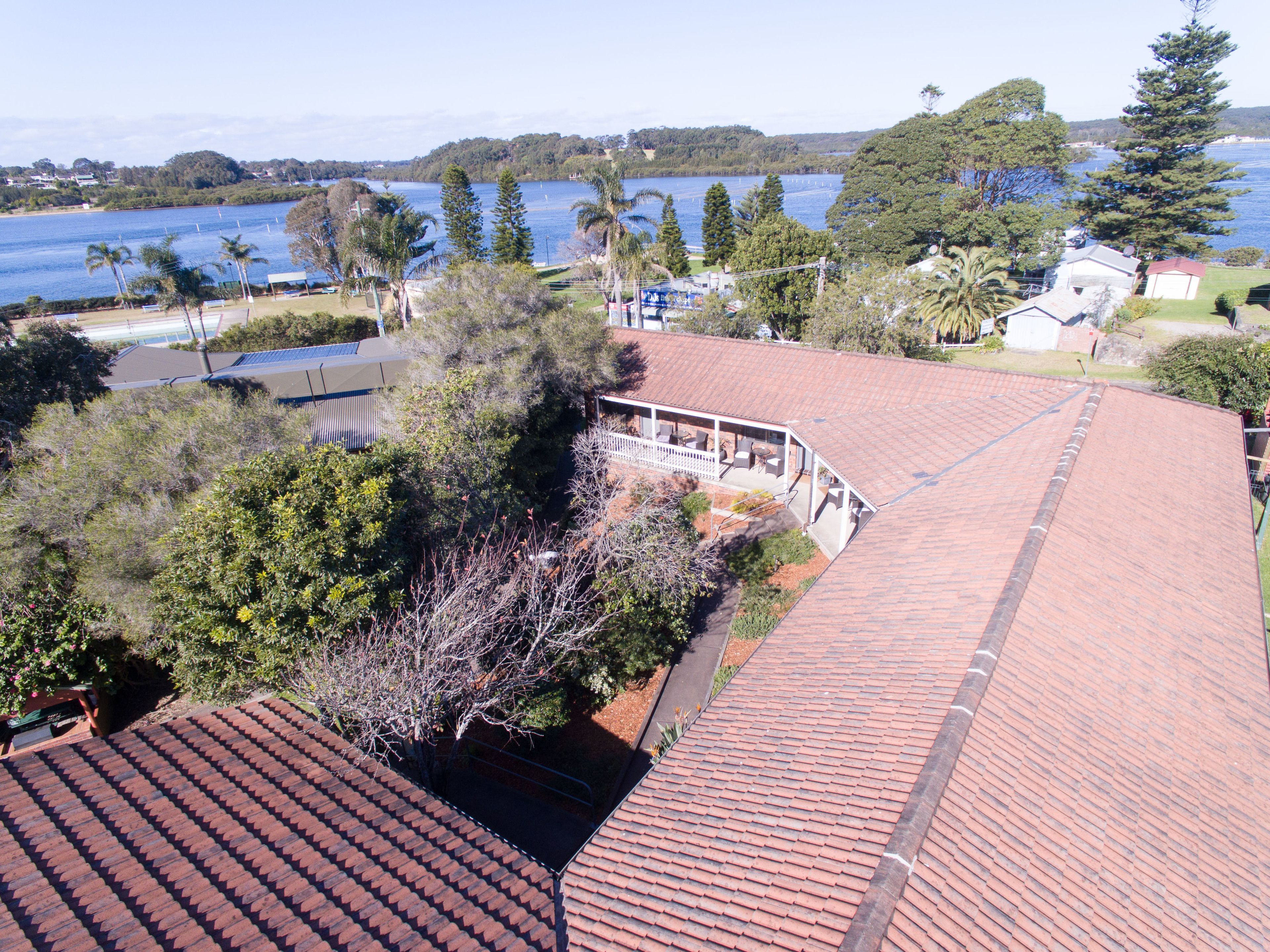 Un quartiere residenziale con tetto in tegole rosse, portico coperto e vista su un lago.