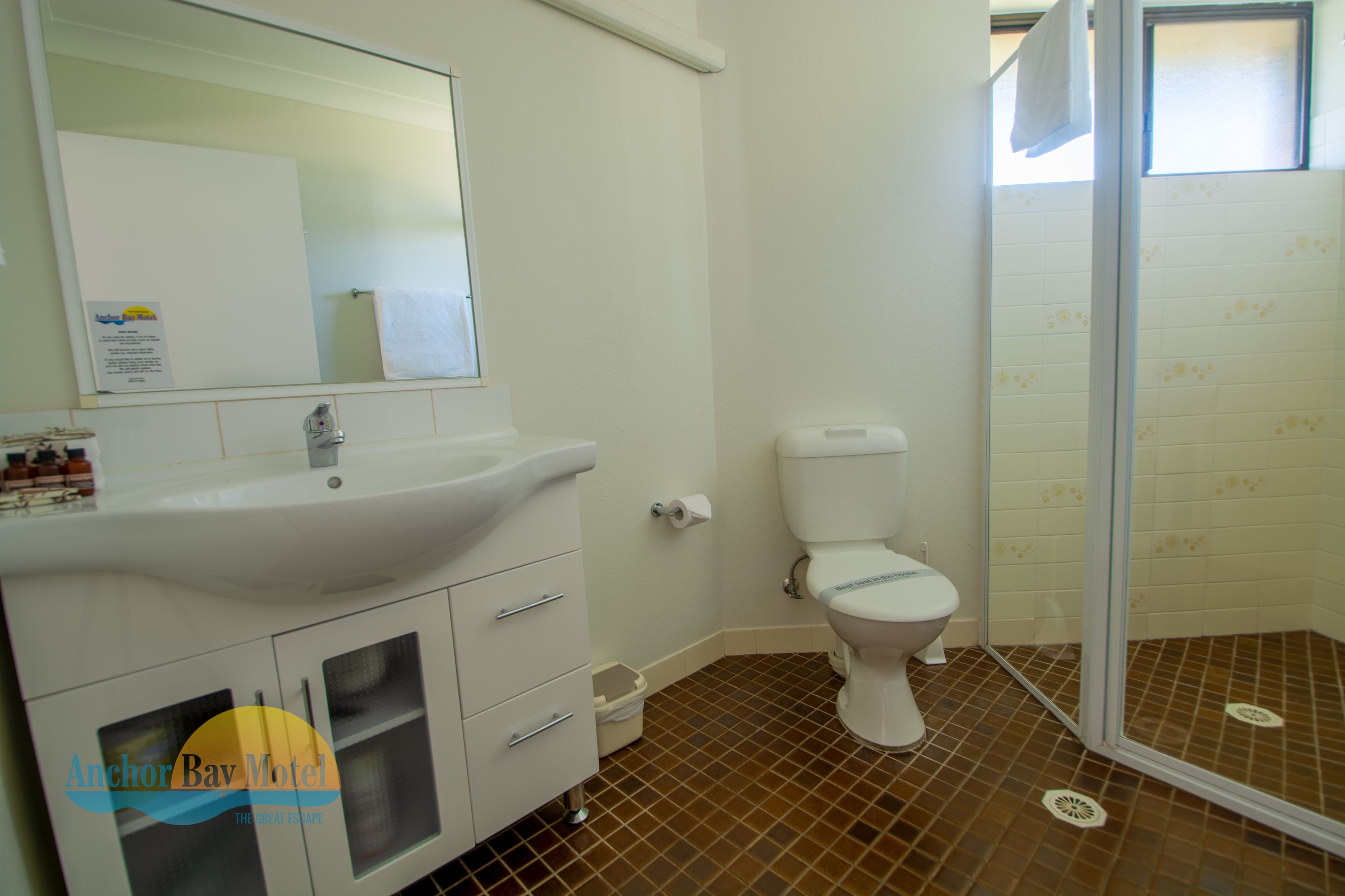 A bathroom with a white sink, toilet, and shower area.