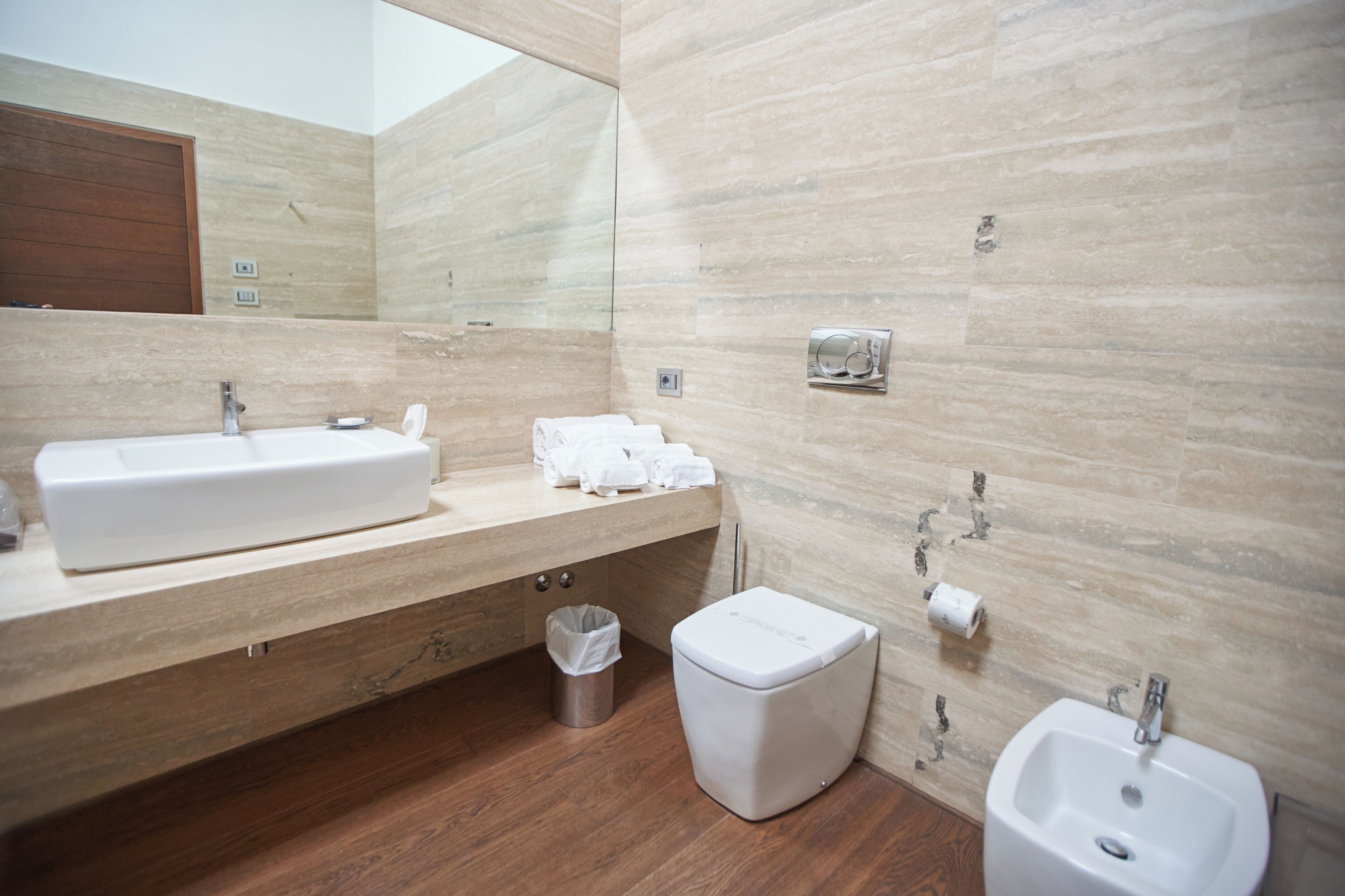 A modern bathroom with a large sink, a toilet, and a bidet.