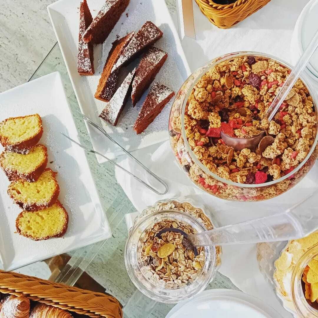 A table with various food items including bread, a cake, and a bowl of cereal.