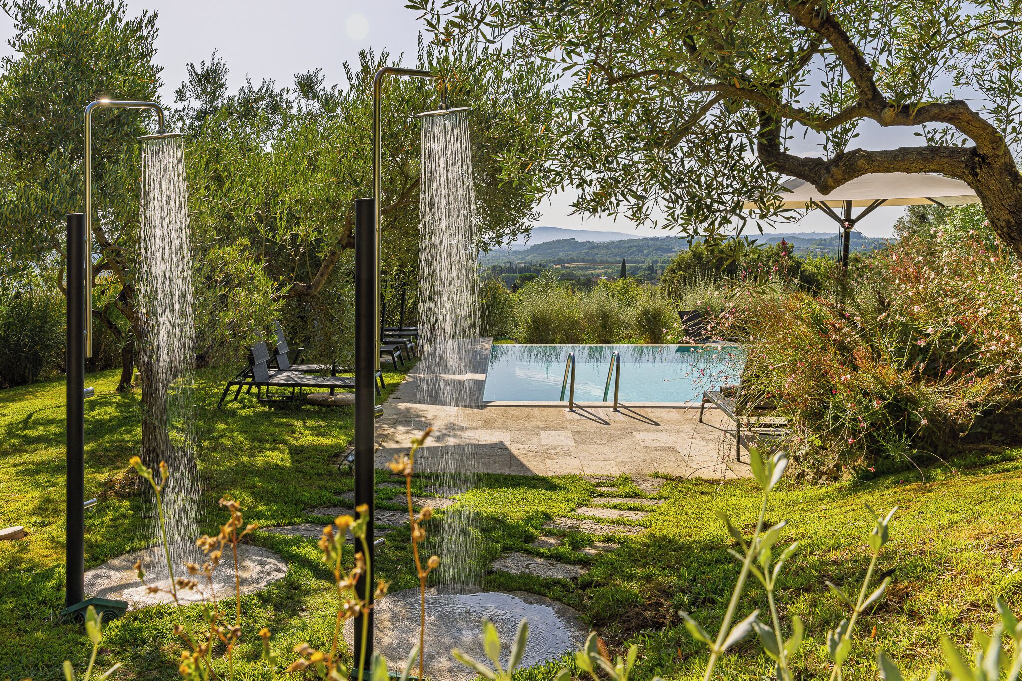 A garden with a pool, a waterfall feature, and outdoor seating.