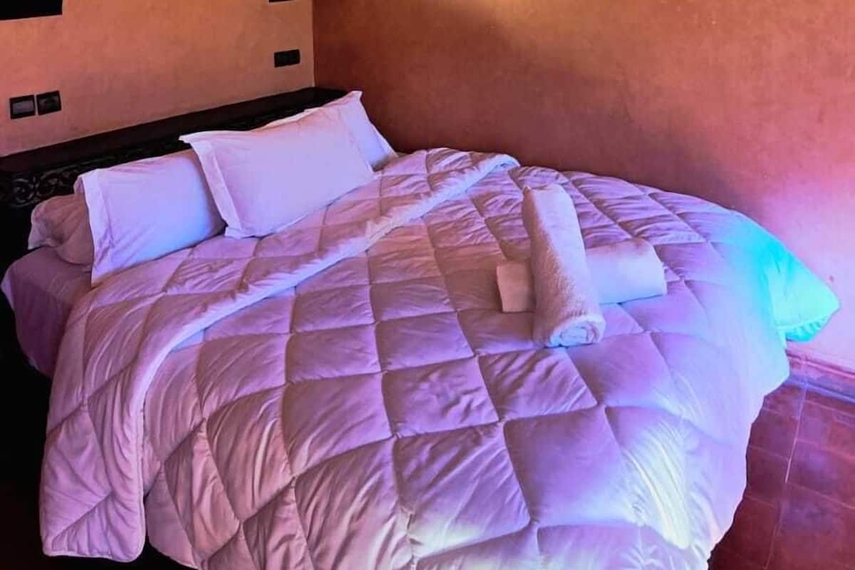 Une chambre à coucher avec un lit, des oreillers et une tête de lit.