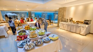 A buffet setup with various food items and a coffee station in a well-lit indoor space.