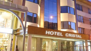 A multi-story hotel with a prominent sign reading "HOTEL CRISTAL".