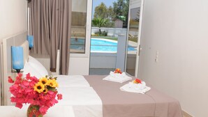 Una habitación de hotel con una cama, un florero y vista a una piscina.