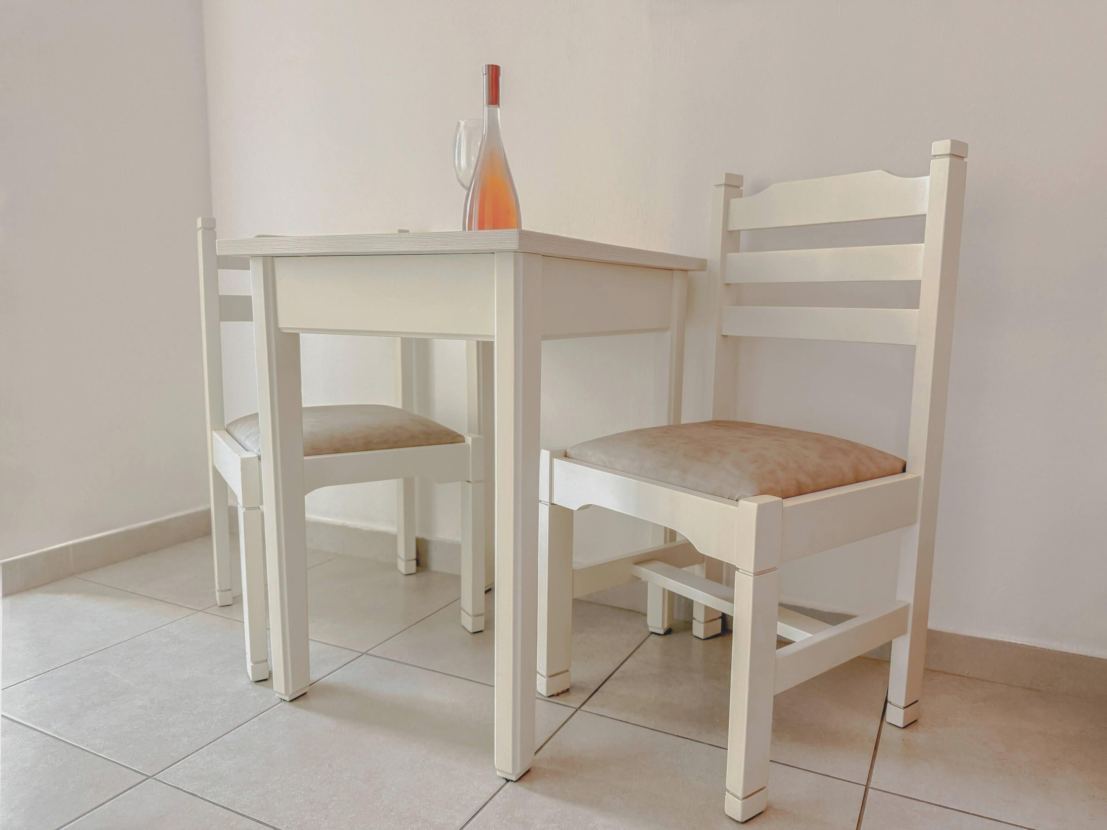 A white table and chair set in a room with tiled flooring.