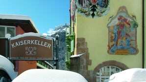 Un bâtiment sur lequel on peut lire l’inscription « KAISERKELLER » et qui possède une fenêtre donnant sur une montagne.