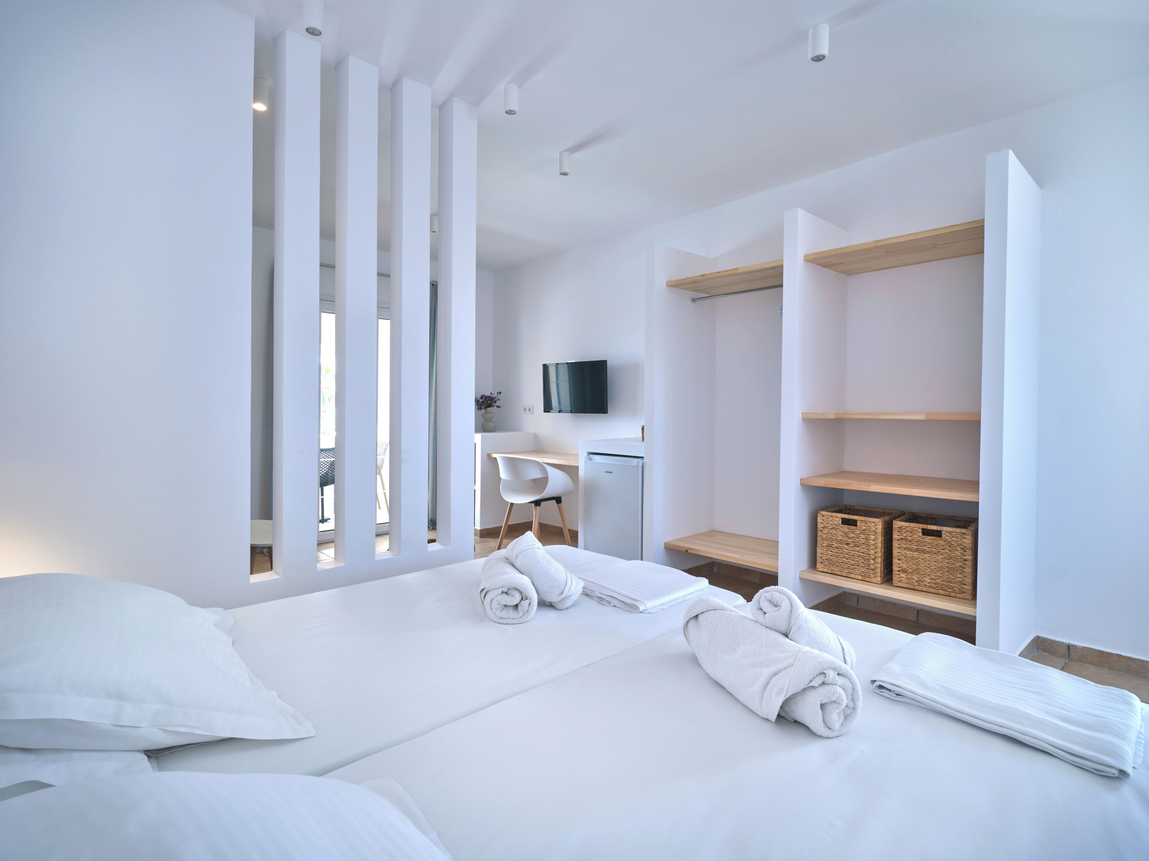 Una moderna camera d'albergo con un letto grande, una scrivania e un televisore.