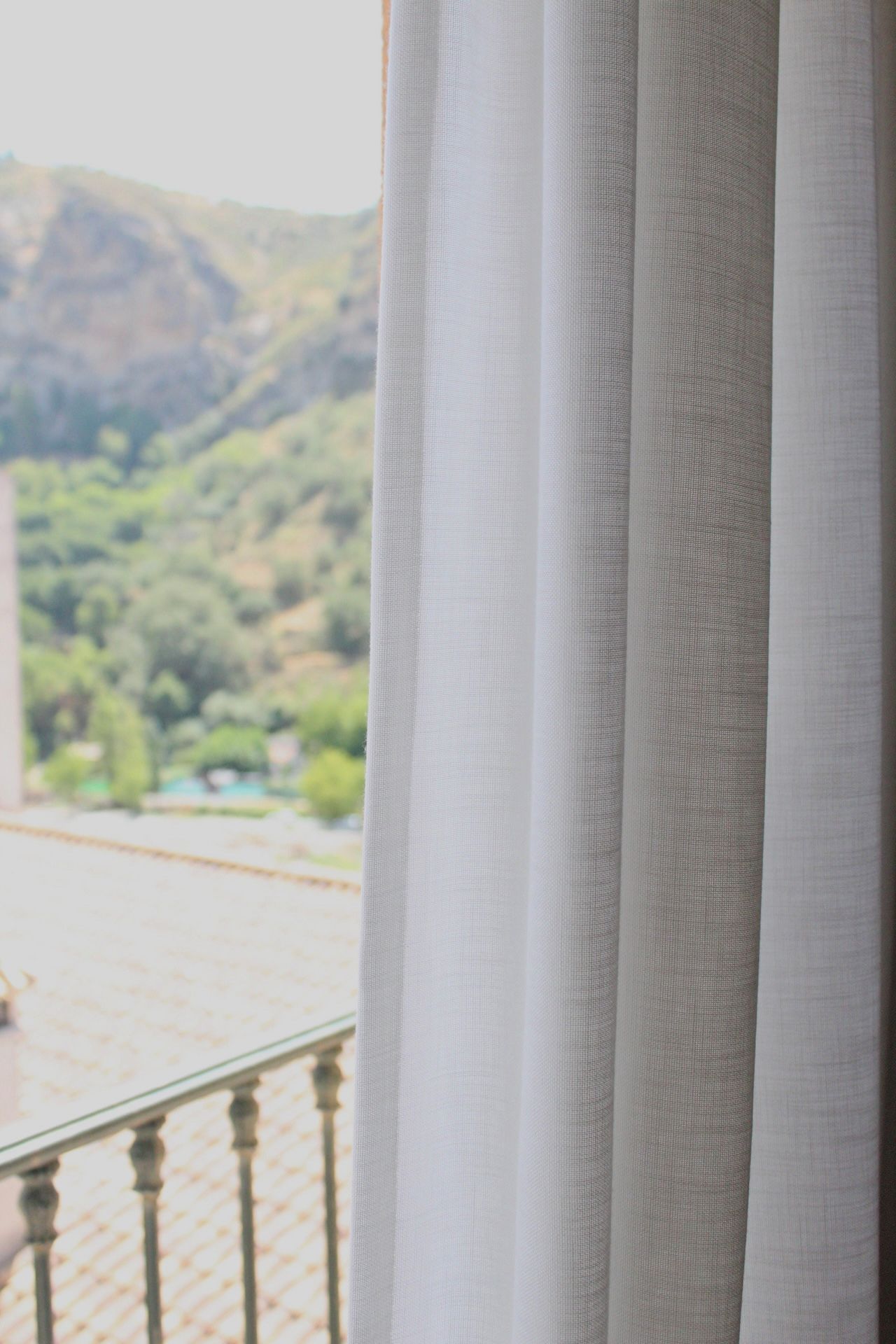 A balcony with a view of a mountainous landscape.